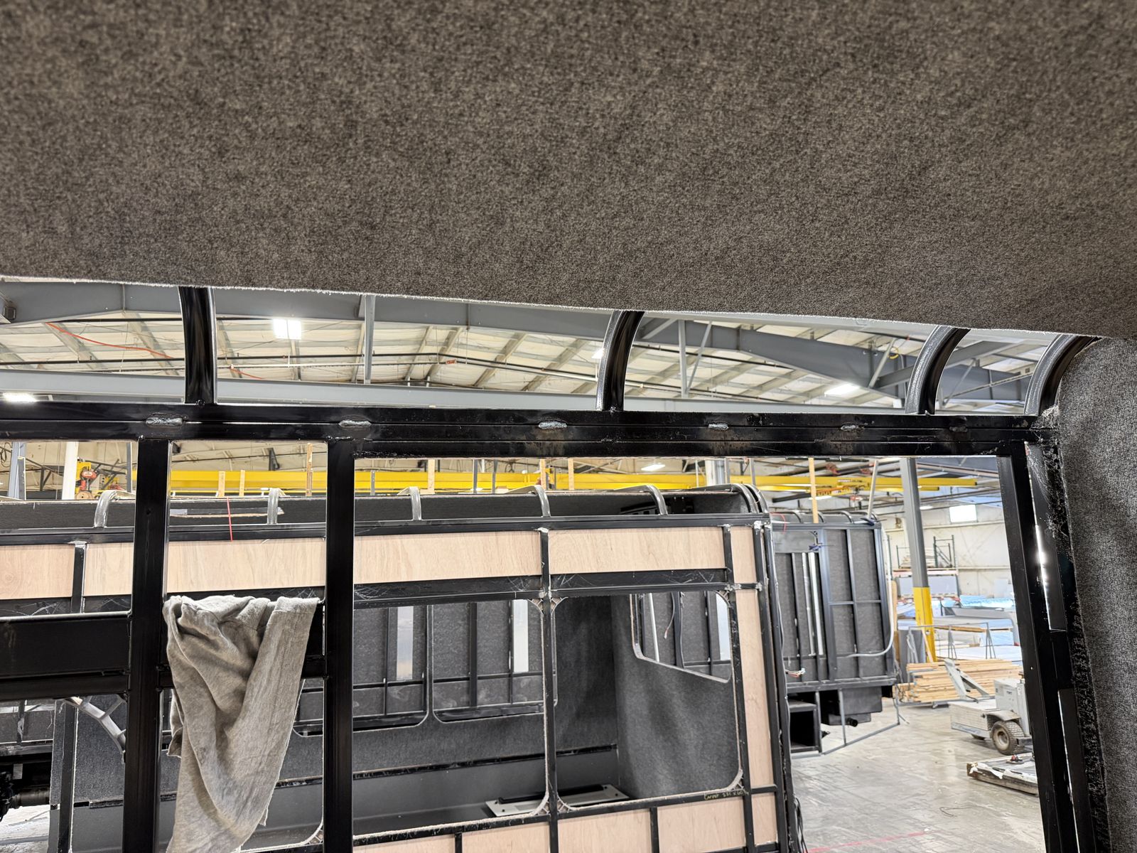 Welded steel roof bows and wheelchair door framing inside a bus body in build