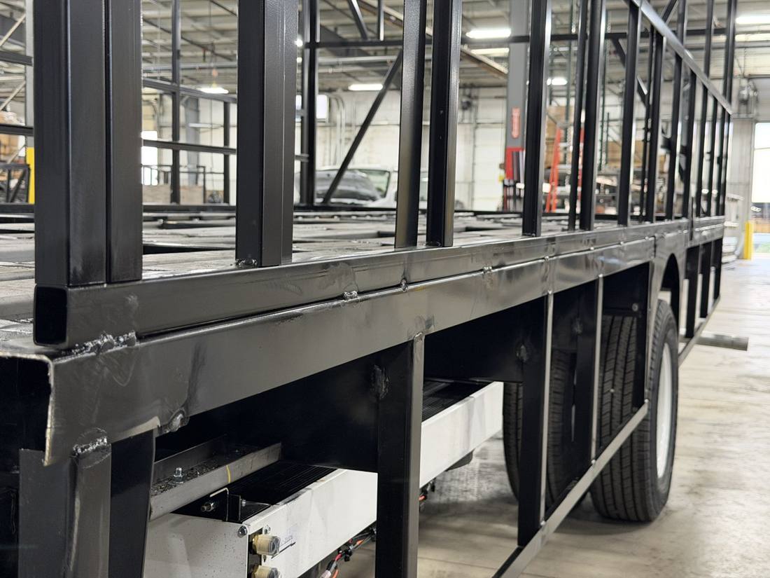 Welded steel skirt structure on an HLE bus cage